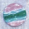 pink sandy shored beach wall art with green ocean channel and swimming sharks